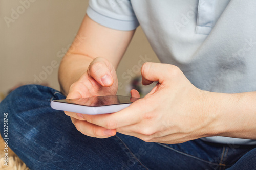 Man using smartphone scrolling through social media, doing swiping, scrolling gestures. Male texting SMS.