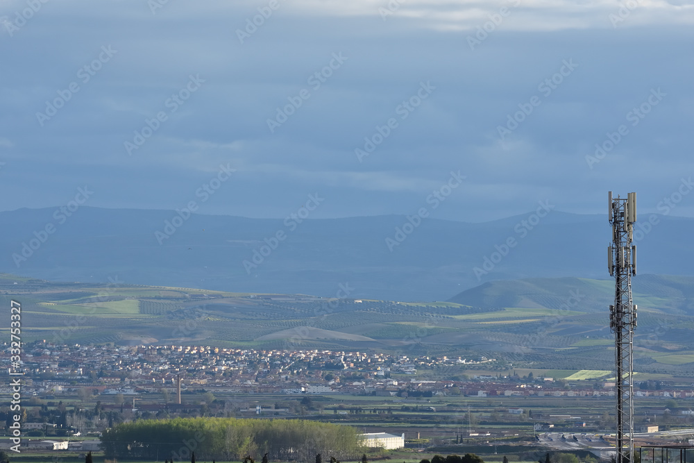 Obraz premium Telecommunications antenna with towns and the fertile plain of Granada in the background