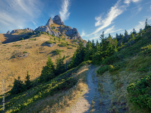 Beautiful morning landscape with a trail to the mountain peak