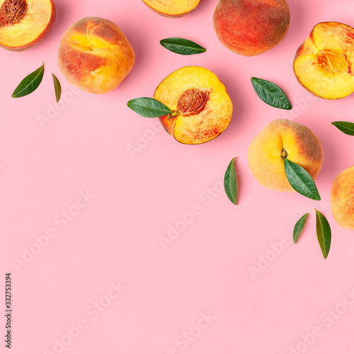 Summer fruit background. Flat lay composition with peaches. Ripe juicy peaches with green leaves on pink background. Flat lay top view copy space. Fresh organic fruit vegan food. Harvest concept photo