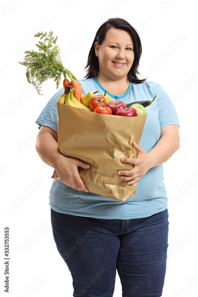 Overweight young woman holding a paper bag with fruits and vegetables Overweight young woman holding a paper bag with fruits and vegetables