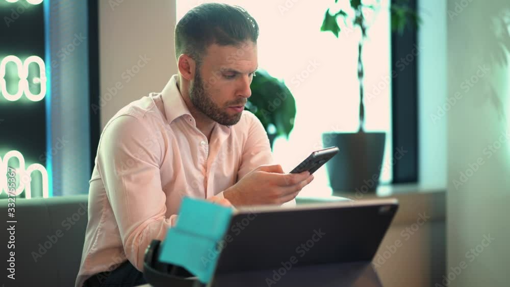 Smart casual man in electronic headphones for noise cancellation having online seminar on modern touch pad for web teaching, millennial male in bluetooth equipment talking during video call