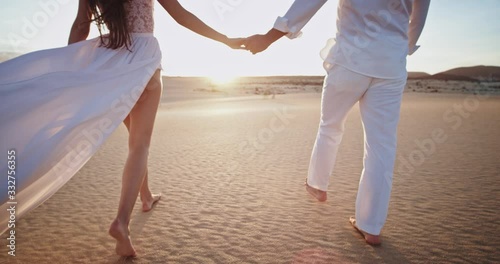 Amazing couple in love in the middle of the beach side they walking around holding hands in amazing sunset time photo
