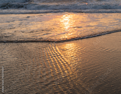 sunrise reflecting as the tide comes in 