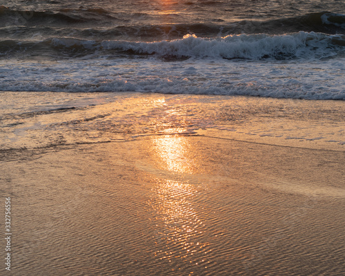 sunrise reflecting as the tide comes in 