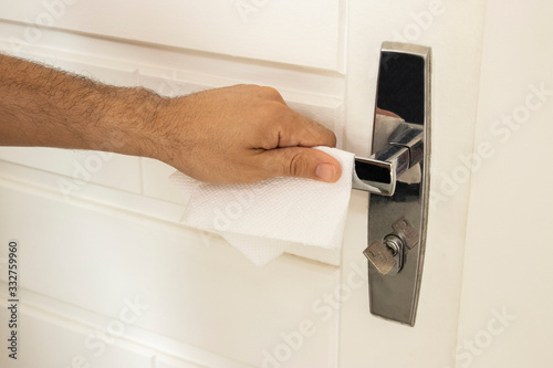 Coronavirus prevention. Man using alcohol gel to clean a door handle. Hygiene concept. Novel coronavirus. (2019-nCoV). Covid-19. photo