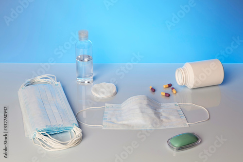 Prevention of the prevention of the epidemic of viral diseases. Bar of soap, alcohol and a medical mask on a blue background