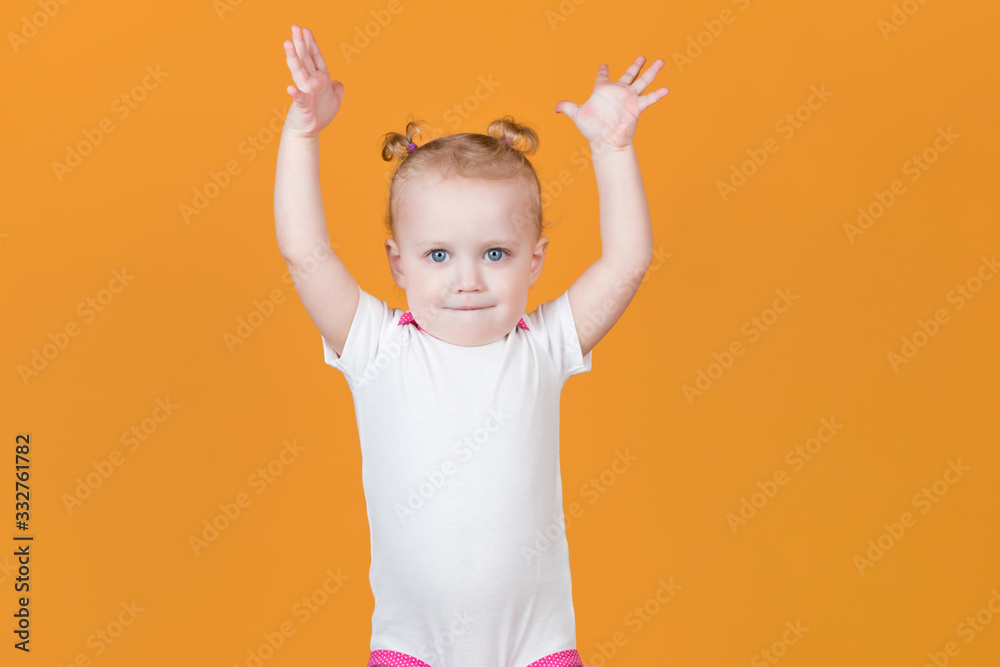 Little girl with ponytails pulls her hands up Little girl with ponytails pulls her hands up