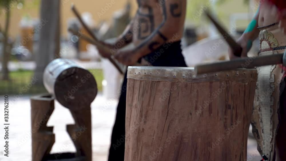 Extreme closeup of Mayan or Aztec drummers playing wooden drums with animals skins and sticks in a park in Valladolid, Mexico. Extreme closeup of Mayan or Aztec drummers playing wooden drums with animals skins and sticks in a park in Valladolid, Mexico.