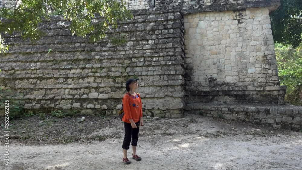 Camera orbiting around a woman looking at the Acropolis at Ek Balam archaeological park in Yucatan, Mexico. Camera orbiting around a woman looking at the Acropolis at Ek Balam archaeological park in Yucatan, Mexico.