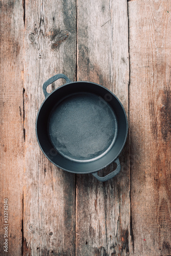 Empty iron pot on wooden background. Top view. Copy space. Healthy, clean food and eating concept. Zero waste. Cooking frame