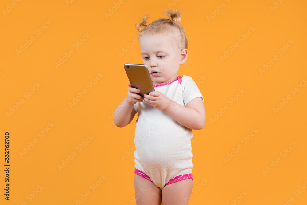 a little girl in a body holds the phone in front of her and looks into it a little girl in a body holds the phone in front of her and looks into it