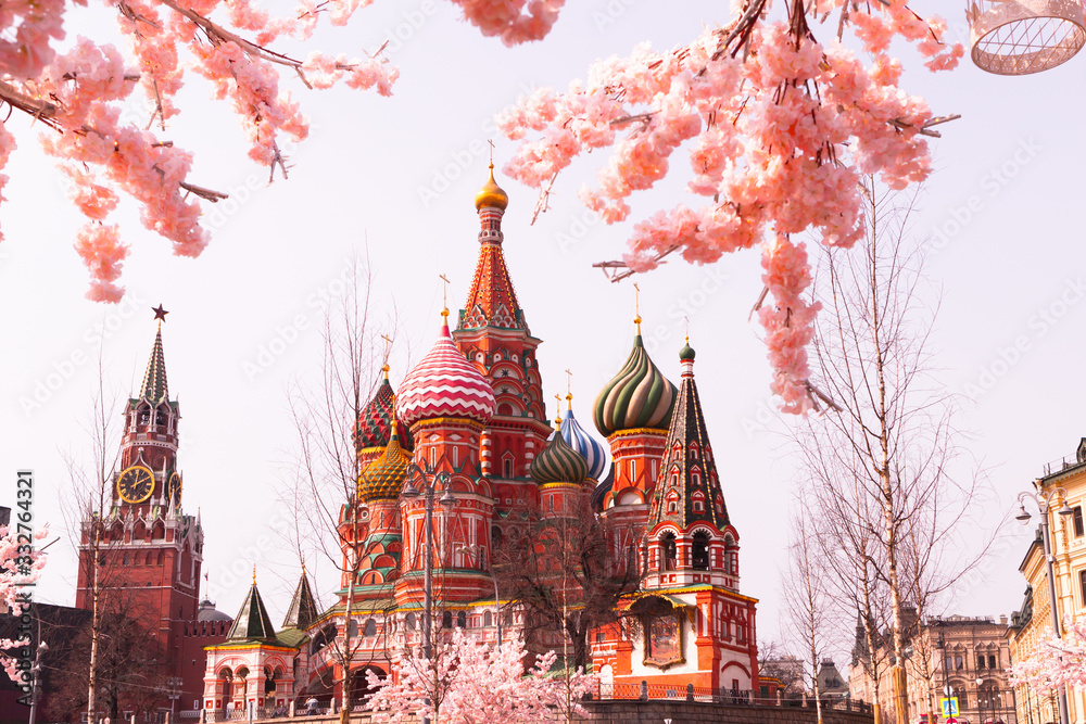 Moscow, Russia, April 16, 2018 - St. Basil's Cathedral, the Kremlin and Vasilyevsky Descent in the spring surrounded by artificial sakura trees, installation.