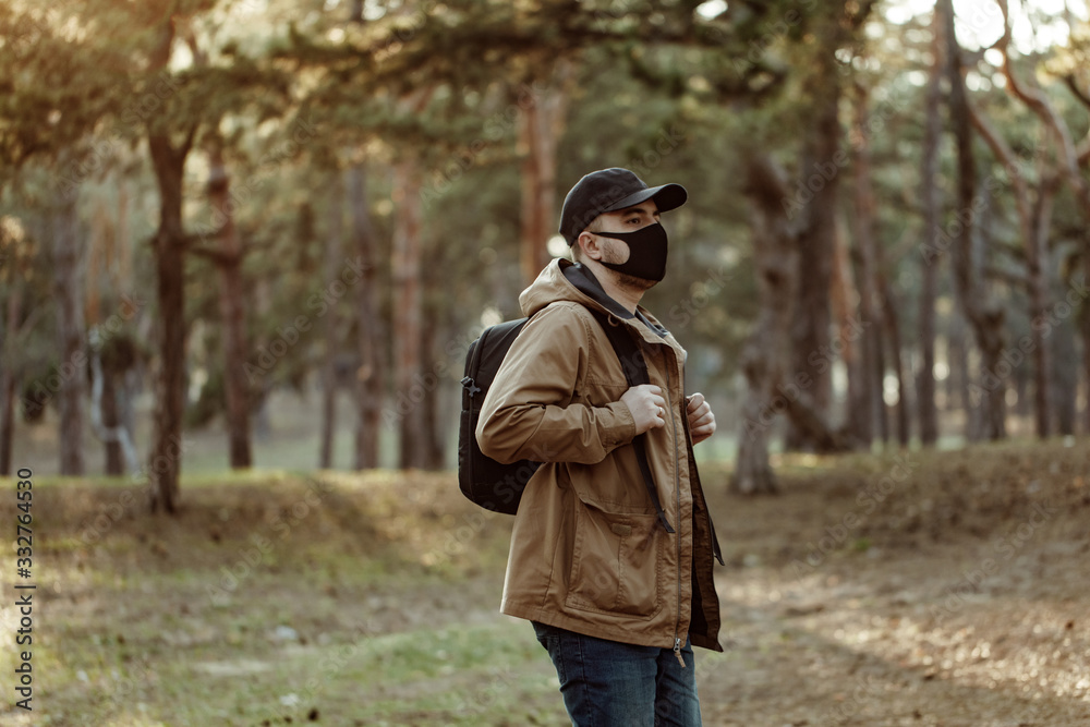 man in medical mask walking in park away from people. man breath fresh air outdoor man in medical mask walking in park away from people. man breath fresh air outdoor