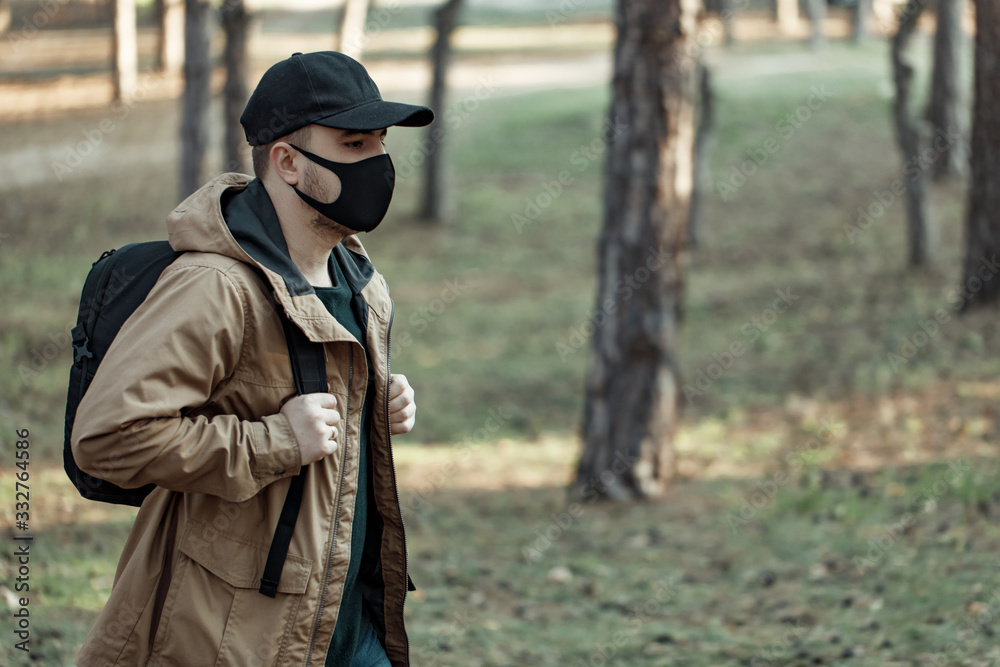 man in medical mask walking in park away from people. man breath fresh air outdoor man in medical mask walking in park away from people. man breath fresh air outdoor