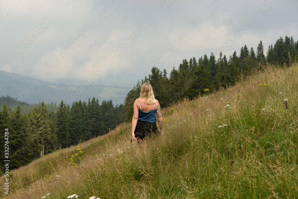 Bergwanderung. Junge Frau im Sommer im hohen Gras