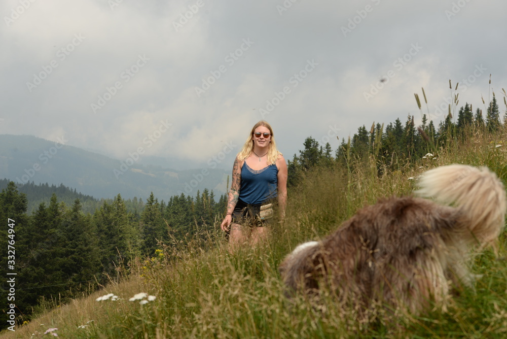 Bergwanderung. Junge Frau im Sommer im hohen Gras