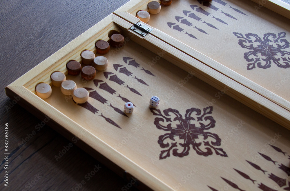 backgammona game of backgammon made of wood lies on a table backgammona game of backgammon made of wood lies on a table