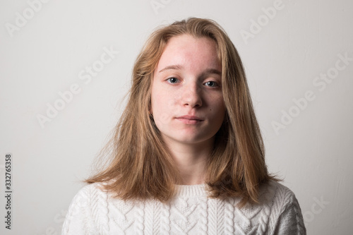Sad teenager girl. Studio image of a cute young girl on a gray background.