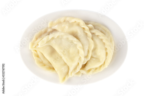 Plate with boiled varenyky, vareniki on white background