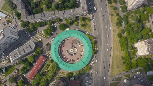 interesting round shape of the building with a green roof, view from the drone, smooth cinematic movement of the drone