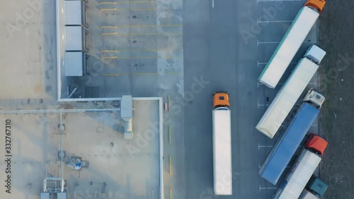 Aerial top down view of a semi-trailer truck travelling along a modern warehouse photo