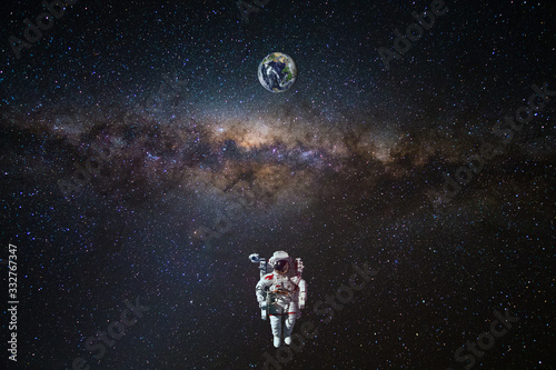 Fototapeta Naklejka Na Ścianę i Meble -  Astronaut in outer space over of the Earth with sun light. City lights on planet. Elements of this image furnished by NASA.