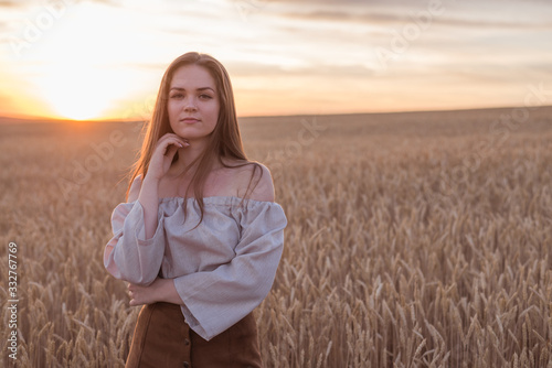 happy woman get high in field of wheat. sunset sky
