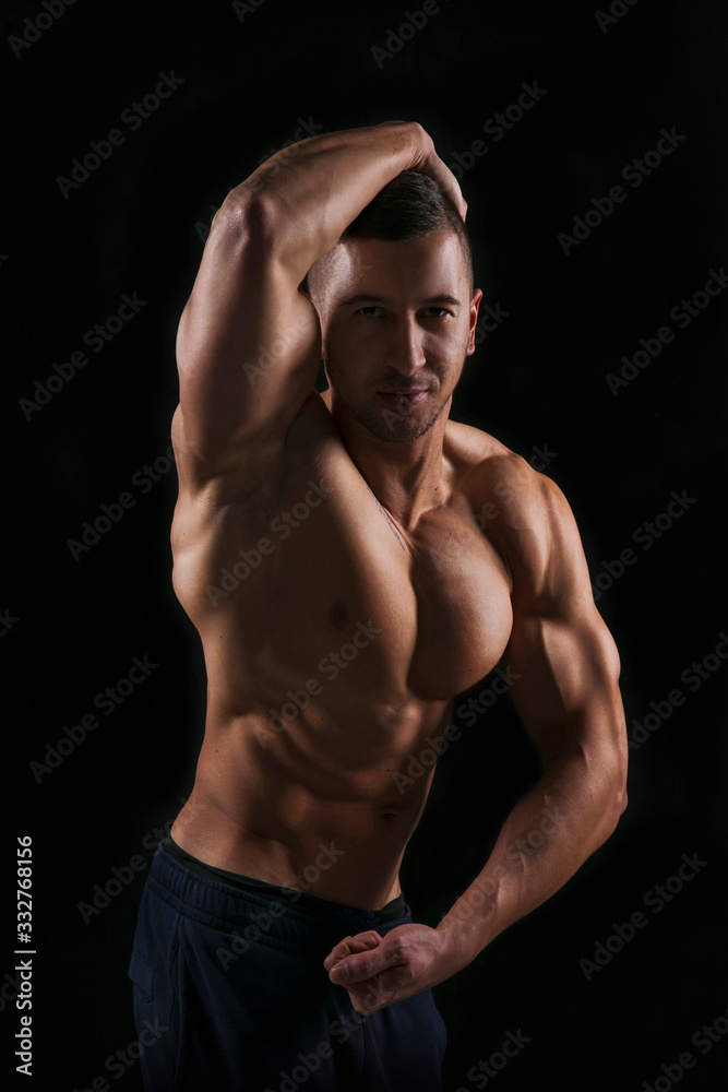 Fototapeta premium Shirtless big bodybuilder posing on black background