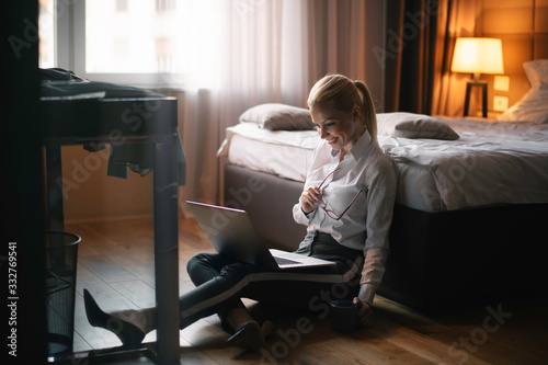 Businesswoman working from a hotel room. Beautiful young woman working on lap top.