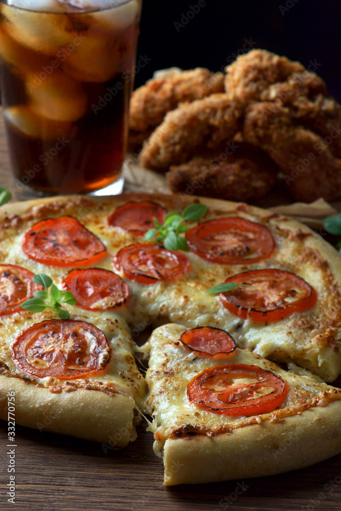 pizza Margarita with a glass of Cola and chicken wings on a wooden background