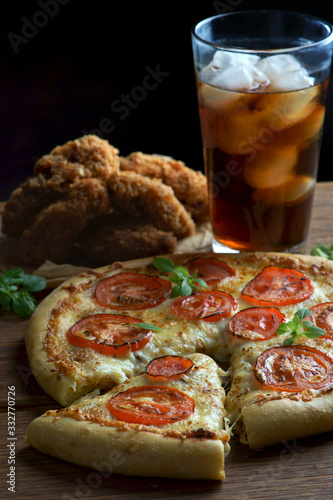 pizza Margarita with a glass of Cola and chicken wings on a wooden background