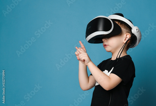 Young boy kid child play virtual reality game in vr glasses and explore alternative reality. Cyber space and virtual gaming
