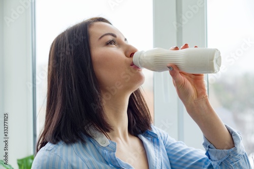 Young beautiful woman with bottle of milk, yogurt, dairy product