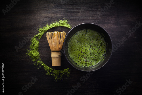 Matcha powder. Organic green matcha tea ceremony. Healthy drink. Traditional japanese drink on black wooden background photo