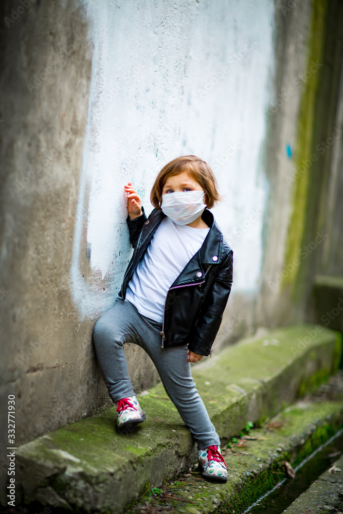 little girl on a walk in a medical mask little girl on a walk in a medical mask