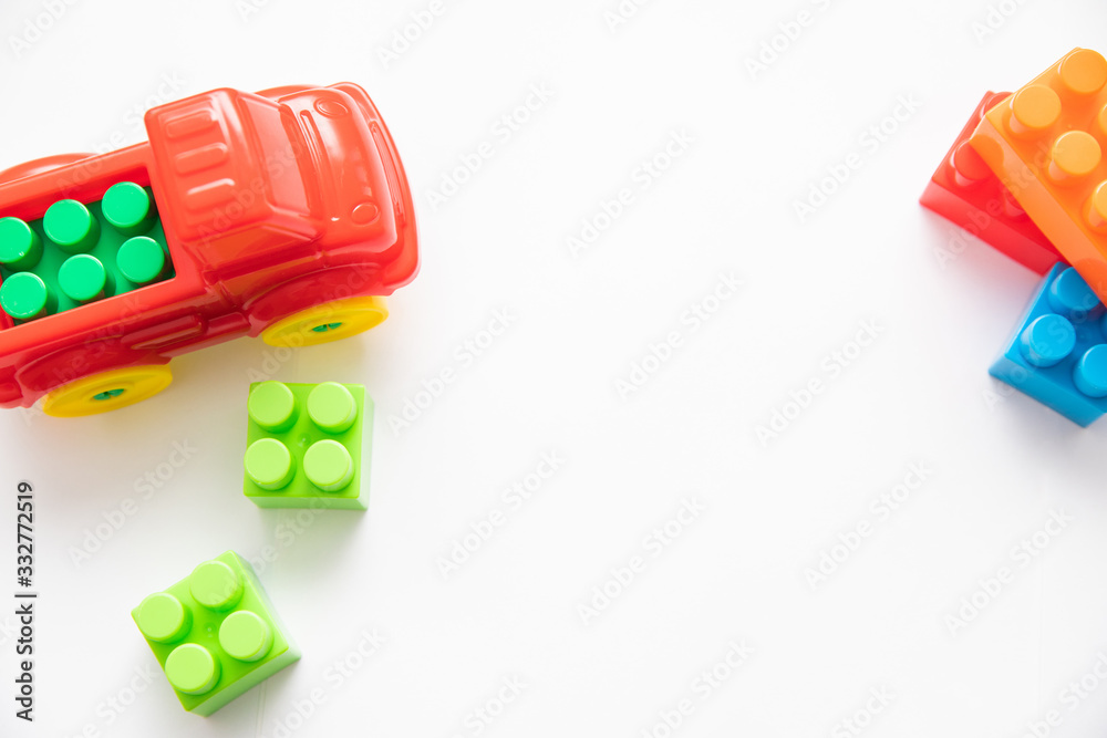 Obraz premium Children's construction kit with cubes and a red car on a white background. Children's entertainment. Development of hand motor skills. logic of thinking.