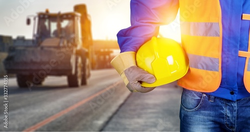 Worker man with helmet in hands on background photo