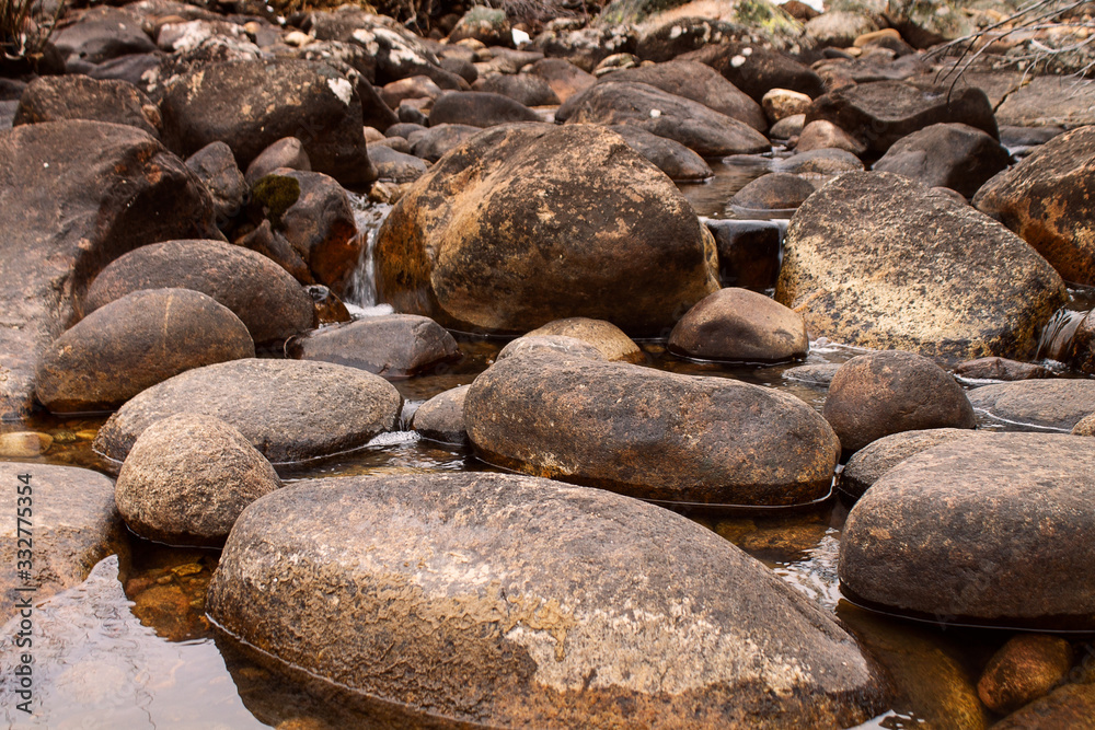 Low closeup shot of river rock tranquil clear river bed calming background Low closeup shot of river rock tranquil clear river bed calming background
