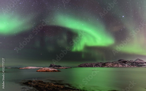 Aurora boreal sobre Sommarøy en la isla de Kvaløy, norte de Noruega en el mes de febrero photo