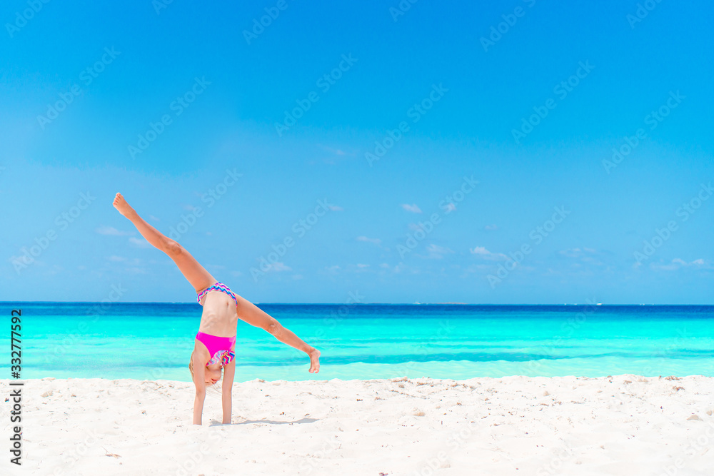 Adorable little girl have fun at tropical beach during vacation Adorable little girl have fun at tropical beach during vacation