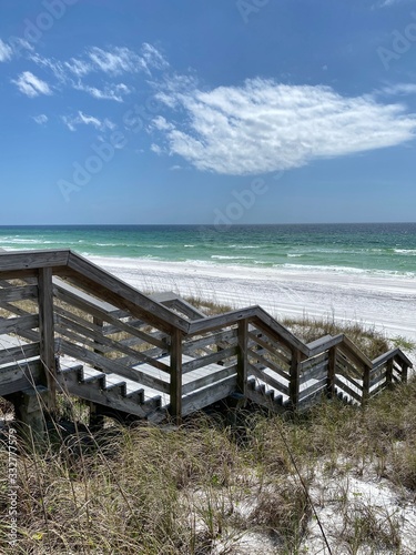 White sand beach in Miramar Beach, Florida with wooden bridge walkway 
