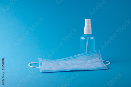 COPY SPACE: Bottle with antiseptic sanitizer and medical mask. Crisis due to coronavirus COVID-19 quarantine. Medical surgical protective face mask with antibacterial antiseptic. Copy space, template.