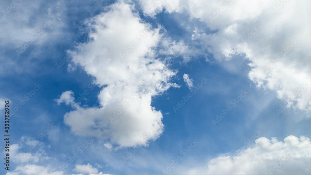Scenic blue sky with beautiful white clouds. Clouds floating on blue sky, 16:9 panoramic format Scenic blue sky with beautiful white clouds. Clouds floating on blue sky, 16:9 panoramic format