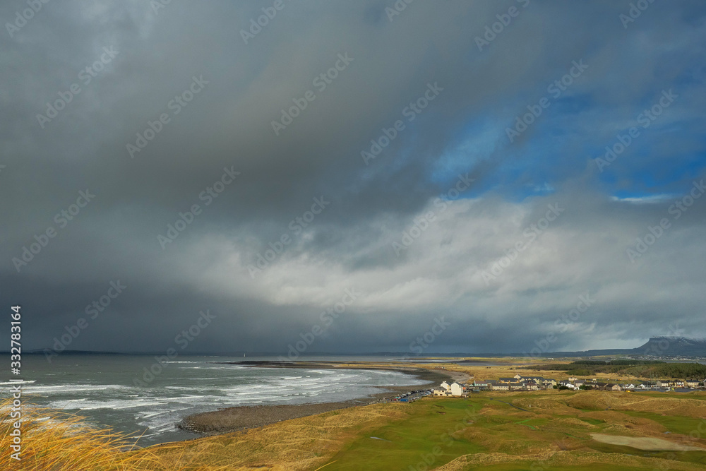 View on Strandhill town and beach, Benbulben in foreground, Dramatic storm clouds. Nobody, county Sligo, Ireland.