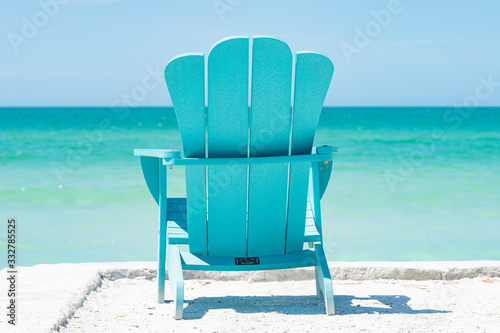 Turquoise Adirondack chair overlooking the beach