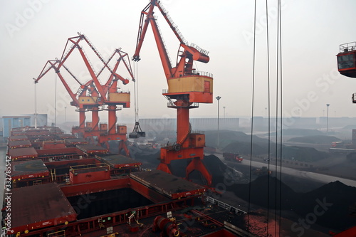 Photography Cargo terminal for discharging coal cargos by shore cranes during foggy weather