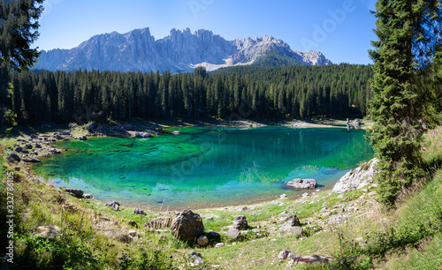 wide angle panorama of the turquoise mountain lake in south tyrol. In the background Tannerwald and the Dolomites mountains
