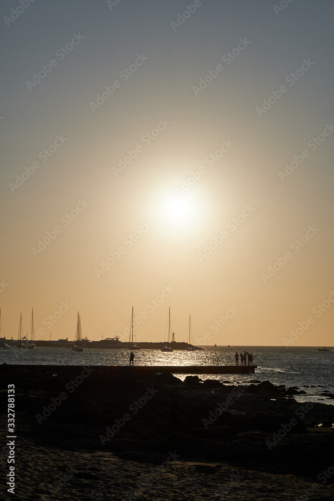 a view of the sunset in the atlantic sea from the rocks of the port of Punta del Este, Maldonado, Uruguay