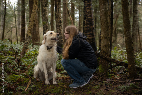 young woman with her dog in the forest